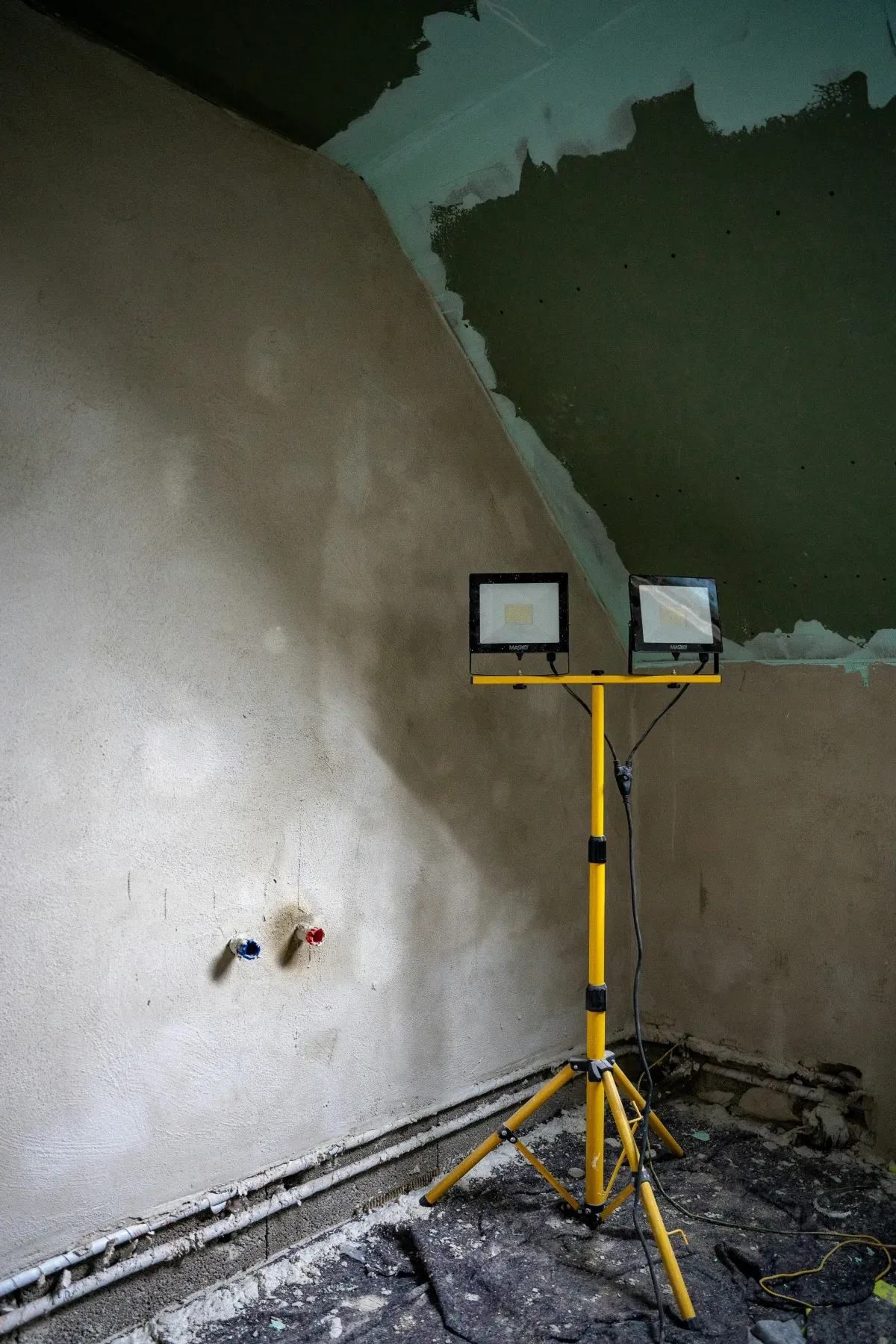 Combles en cours de rénovation : plaques hydrofuges posées au rampant, projecteur de chantier